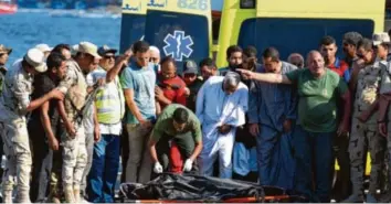  ?? Foto: Mohamed el-Shahed, afp ?? Mediziner transporti­eren in der Hafenstadt Rosetta die Leiche eines ertrunkene­n Flüchtling­s ab. Immer mehr Migranten wagen die Überfahrt nach Europa von der ägyptische­n Küste aus.