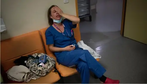  ?? AP Photo/Daniel Cole, File ?? A nurse takes a break in her New Year's Eve shift in the COVID-19 intensive care unit at the la Timone hospital in Marseille, France, Dec. 31, 2021.