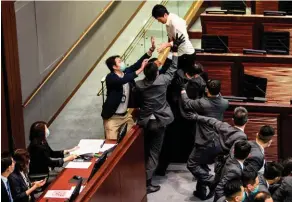  ??  ?? Trouble-fête.
Le démocrate Ted Hui (chemise blanche), lors d’un affronteme­nt au sein du Conseil législatif (LegCo), le 18 mai.