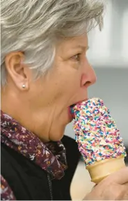  ?? ?? Karen Yonney of Egypt takes a taste of her vanilla soft-serve ice cream with rainbow sprinkles Thursday at King Kone’s new location.