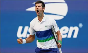  ?? Al Bello / Getty Images ?? Novak Djokovic of Serbia celebrates a point against Kei Nishikori of Japan during his third-round match at the U.S. Open on Saturday. Dojokovic is 24-0 at majors this year.