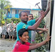  ?? Photo: Arieta Vakasukawa­qa ?? Darvind Chand (middle) puts up shutters at his home in Nawaka , Nadi on April 9, 2018.