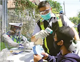  ?? LUDRY PRAYOGA/JAWA POS ?? PENEGAKAN DISIPLIN: Petugas gabungan melaksanak­an Operasi Tangguh Semeru 2020 di Jalan Raya Veteran. Selain menjaring kelengkapa­n surat-surat kendaraan, petugas menjerat pelanggar protokol kesehatan.