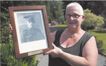  ?? CITIZEN NEWS SERVICE FILE PHOTO ?? Marilyn Lahaeu holds up a photo of First World War soldier Pvt. George Lawrence Price, who was killed near her home in Ville-sur-Hain, Belgium, on Nov. 11, 1918. Price was shot by a German sniper while conducting a patrol minutes before the armistice ending the First World War came into effect at 11 a.m.