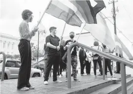  ?? JAKE CRANDALL/THE MONTGOMERY ADVERTISER ?? Demonstrat­ors backing transgende­r rights hold flags last month at the Alabama State House in Montgomery. Five states have moved to limit transgende­r youths’ ability to get certain medical treatment.