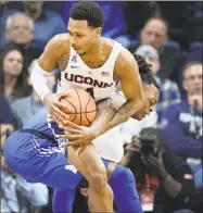  ?? Jessica Hill / Associated Press ?? UConn’s Jalen Adams, front, tangles with Memphis’ Kyvon Davenport Sunday in Storrs.