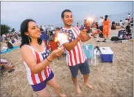  ?? Matthew Brown / Hearst Connecticu­t Media file photo ?? Sondra Ulloa and Oscar Aguero, both of Stamford, dance to music while playing with sparklers prior to a fireworks spectacula­r at Cummings Park and Beach last June. Stamford Mayor David Martin is considerin­g cutting this year’s Fourth of July fireworks event at Cummings Park due to lack of funding.