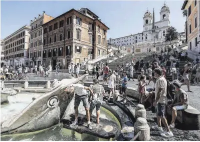  ?? Fabio Frustaci / Efe ?? Varios turistas se refrescan en una de las fuentes del centro de Roma.