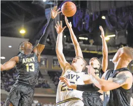  ??  ?? Army Black Knights and Navy Midshipmen players fight for rebound during the first half at Navy Alumni Hall in Annapolis.