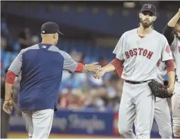  ?? AP PHOTO ?? CAN’T ROLL A SEVEN: Rick Porcello hands the ball to manager Alex Cora as he is pulled from the Red Sox’ eventual 8-5 loss to the Blue Jays last night, snapping the team’s win streak at six.