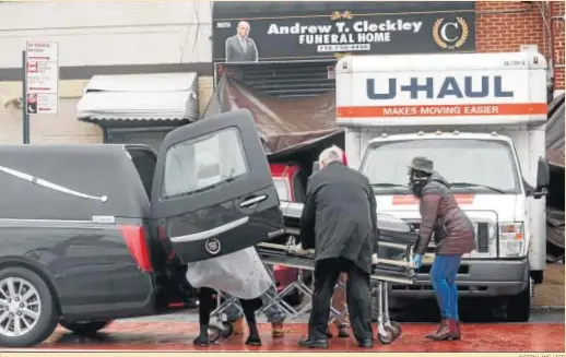  ?? JUSTIN LANE / EFE ?? Varias personas introducen un féretro en un coche ante la funeraria en la que fueron hallados los camiones con los cuerpos en Nueva York.