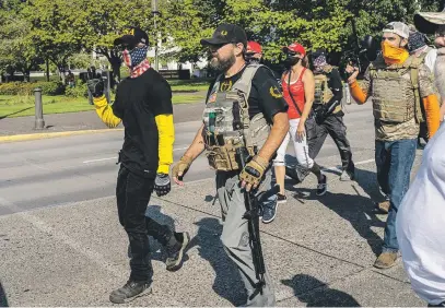  ?? Picture: AFP ?? BEHIND THEIR MAN. Proud Boys members arrive as a pro-Trump caravan rally convenes at the Oregon State Capitol building in Salem yesterday. The caravan event, billed as the Oregon For Trump 2020 Labour Day Cruise Rally, began in Clackamas and made its way to Salem.