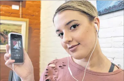  ?? MILLICENT MCKAY/JOURNAL PIONEER ?? Hailey MacIsaac, 20, listens to her recently released single “Real Luv”. The song is available on Spotify, Google Play, iTunes and Apple Music.