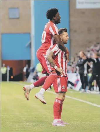  ??  ?? Josh Maja helps Chris Maguire celebrate his goal at Gillingham last night.