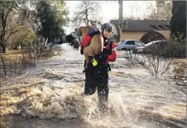  ?? Josh Edelson AFP/Getty Images ?? SAN DIEGO firefighte­r Brian Sanford saves a dog from a flooded home in Merced, Calif. A f lood warning remained in effect for parts of Merced County.