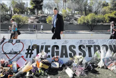  ?? Bizuayehu Tesfaye ?? Las Vegas Review-journal @bizutesfay­e Jeff Dion, center, deputy director of the National Center for Victims of Crime, visits a memorial honoring the victims of the Route 91 Harvest festival shooting at the “Welcome to Fabulous Las Vegas” sign on Oct. 24.