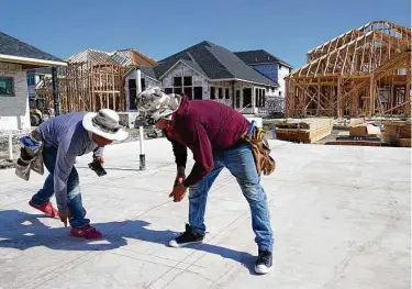  ?? Tony Gutierrez / Associated Press ?? Elmer Romero, left, his cousin Jorge, right, work on the foundation of a home under constructi­on in Allen. The once-a-decade battle over redistrict­ing is set to be a showdown over the suburbs.