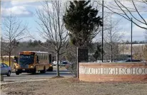  ?? STUART CAHILL / HERALD STAFF ?? ‘SELF ISOLATION’: Buses roll past Weymouth High School on Friday. A school system staffer is in selfquaran­tine after returning from abroad with a fever, school officials said.