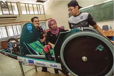  ??  ?? (From left) Car driver Mohammad Shamir Jamil, Amirah Athirah Rohazam and Afif Nor Norazman discussing about the internal components of the prototype car.