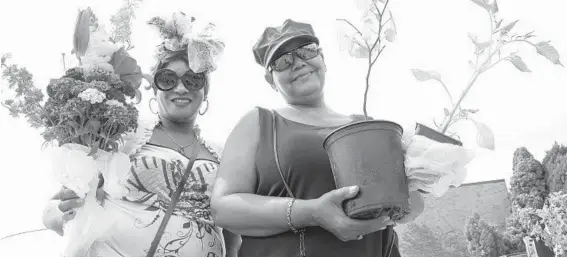  ?? ALGERINA PERNA/BALTIMORE SUN PHOTOS ?? Crystal Ray, left, and Grace Strawder show off their fiids at the Edmondson Village Farmers’ Market. The two sisters were among the opening-day patrons of the market. The Edmondson Village market — the only farmers’ market on the city’s west side — has...