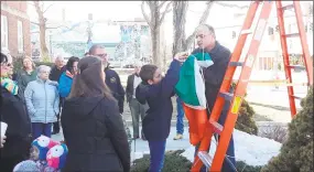  ?? Emily M. Olson / Hearst Connecticu­t Media ?? The family of the late Tim Driscoll visited City Hall Monday to honor him as the 2019 Lord Mayor of Torrington, an honor bestowed on Irish Americans from the city. Above, custodian John Lombardi helps raise the Irish flag outside City Hall.