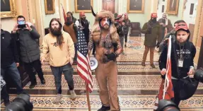  ?? PHOTOS BY SAUL LOEB/AFP VIA GETTY IMAGES ?? Jake Angeli, center in horned hat, is among supporters of President Donald Trump who breached security enter the Capitol on Wednesday as Congress met to confirm the 2020 presidenti­al election.