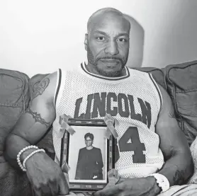  ?? EBONY COX/MILWAUKEE JOURNAL SENTINEL ?? Michael Washington holds a photo of his sister, Sherida Davis, who was killed in 2017.