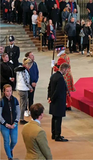 ?? ?? A moment with Her Majesty: David Beckham stands respectful­ly by the Queen’s coffin as he pays tribute to her years of service. He rejected an MP’s offer to skip the line as he felt it was his duty to queue