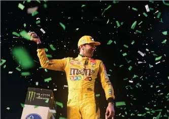  ?? JARED C. TILTON / GETTY IMAGES NORTH AMERICA ?? VICTORY IS MINE: Kyle Busch, driver of the No. 18 M&M's Toyota, celebrates in Victory Lane after winning the Monster Energy NASCAR Cup Series Ford EcoBoost 400 and the Monster Energy NASCAR Cup Series Championsh­ip at Homestead Speedway in Homestead, Florida, on Sunday.