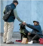  ?? JOSEPH JOHNSON/STUFF ?? A homeless man is handed a coffee by a passer-by on a freezing winter morning in Colombo St, central Christchur­ch.