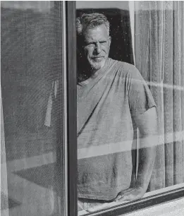  ?? BRIDGET BENNETT/NYT ?? Carl Tuch, father of Las Vegas Golden Knights forward Alex Tuch, looks out of Alex’s Las Vegas home, where he quarantine­d in hopes of being allowed to go watch Alex play.