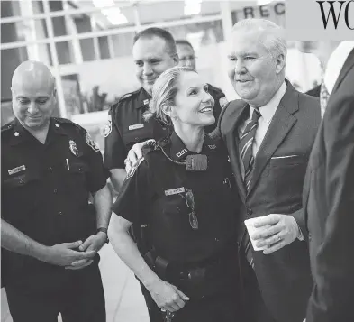  ?? WILL VRAGOVIC / TAMPA BAY TIMES VIA AP ?? Tampa Mayor Bob Buckhorn congratula­tes police officer Randi Whitney on the arrest of a suspect in four random slayings in the Seminole Heights area of the city. Buckhorn said the arrest brought relief to an anxious community.