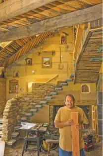  ?? NEW YORK TIMES FILE PHOTO ?? Isabro Ortega, a self-taught woodcarver, is surrounded by the tools of his trade in 2012 at his home in Truchas. The home, which he began carving in 1984, was still a work in progress at the time of his death last week.