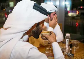  ??  ?? Trendy comfort: A customer sipping a cup of coffee at the Flat White cafe in Doha’s Tawar Mall. — AFP