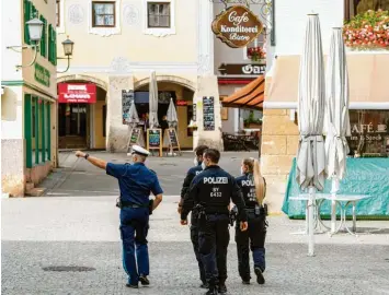  ?? Foto: Lennart Preiss, Getty Images ?? Polizeibea­mte streifen am Dienstag durch das Zentrum von Berchtesga­den, um die Einhaltung der drastisch verschärft­en Coro‰ na‰Regeln zu kontrollie­ren.
