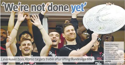  ?? AFPPIX ?? Leverkusen boss Alonso targets treble after lifting Bundesliga title
Bayer Leverkusen’s head coach Xabi Alonso (right) celebrates with a mock-up of the Bundesliga trophy with his players after their Bundesliga match. –