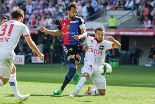  ?? (AFP PHOTO/FABRICE COFFRINI) ?? Le Bâlois Matias Delgado marque le premier but pour son équipe à la 47e minute, malgré l’interventi­on du défenseur sédunois Nicolas Luchinger.