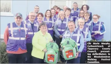  ?? ?? Cllr Marie Murphy, Cathaoirle­ach of Tipperary County Council, presenting defibrilla­tors to the Rhododendr­on Walking Festival Committee.