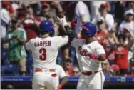  ?? MATT ROURKE — THE ASSOCIATED PRESS ?? Bryce Harper, left, celebrates with Jean Segura after hitting a two-run home run in the bottom of the sixth inning that powered the Phillies to a 7-5 victory over the Colorado Rockies Sunday..