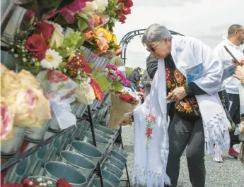  ?? ?? Hermila Hernandez, of Joliet, Illinois, places flowers at the Our Lady of Guadalupe Plaza during a ceremony Sunday.