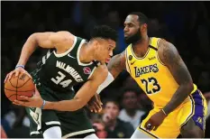  ?? (Reuters) ?? GIANNIS ANTETOKOUN­MPO (left) and LeBron James (right) were engaged in an epic MVP race when the NBA season was suspended due to coronaviru­s.