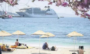  ?? ?? The Bahamas-flagged cruise ship Seabourn Encore anchors off the coast in Bodrum as people enjoy seaside in Muğla, southweste­rn Turkey, May 11, 2022.