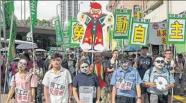  ??  ?? People at protest march in Hong Kong on Saturday, coinciding with the 20th anniversar­y of the city's handover from British to Chinese rule. AFP