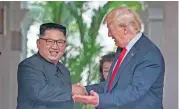  ?? [AP PHOTO] ?? U. S. President Donald Trump shakes hands with North Korean leader Kim Jong Un at the Capella resort on Sentosa Island Tuesday in Singapore.