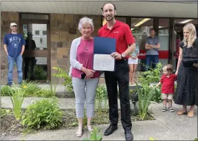  ?? SKYE MASON PHOTO ?? Kyle Magne stands with a representa­tive from Assemblywo­man Carrie Woerner’s office during a ribbon-cutting ceremony at Magne’s new State Farm agency in Saratoga Springs.