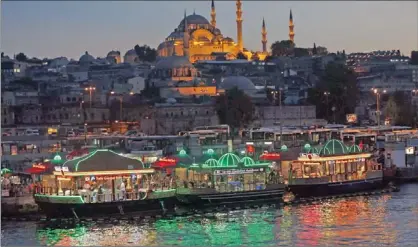  ?? PIC: REUTERS ?? ISTANBUL: Boats selling fish sandwiches at the Golden Horn, with Sabanci Mosque in the background .