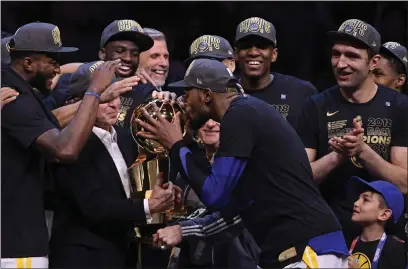  ?? JOSE CARLOS FAJARDO – STAFF PHOTOGRAPH­ER ?? Kevin Durant kisses the Larry O'Brien trophy as he celebrates with his Warriors teammates after winning the NBA title by sweeping the Cleveland Cavaliers in 2018. Durant also helped the team win the championsh­ip the previous season and was a two-time Finals MVP.