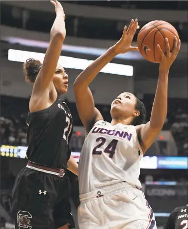  ?? Jessica Hill / Associated Press ?? UConn’s Napheesa Collier, right, shoots over South Carolina’s Mikiah Herbert Harrigan during Monday night’s 97-79 win. Collier finished with 31 points, 16 rebounds and six assists.