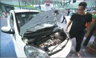  ?? SU YANG / FOR CHINA DAILY ?? A visitor examines a new energy car at an auto exhibition in Nanjing, Jiangsu province, in early September.