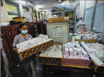  ?? (AP/Eranga Jayawarden­a) ?? A hospital worker carries a tray of medicine June 6 at a government-run hospital in Colombo.